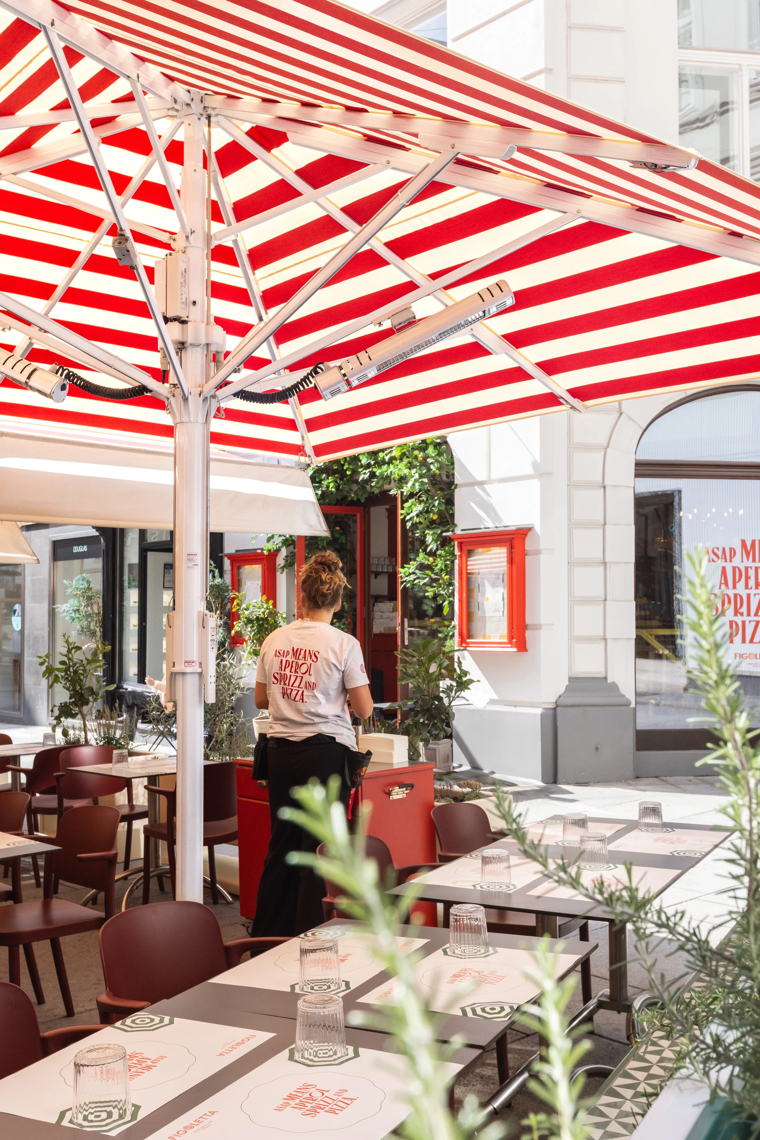 Restaurant Außenbereich mit Sonnenschirm und Servicekraft